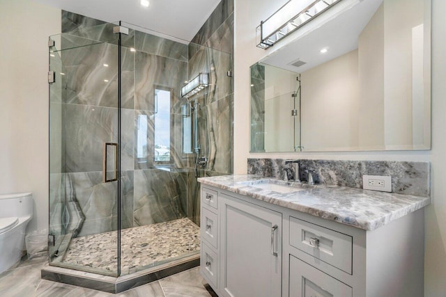 full bath with visible vents, a marble finish shower, vanity, and toilet