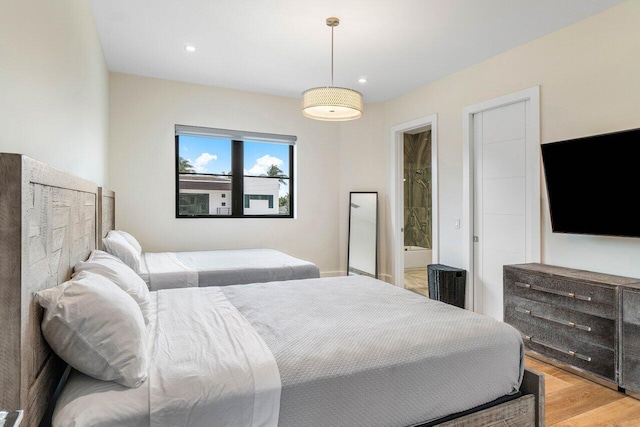 bedroom featuring recessed lighting, light wood finished floors, and ensuite bathroom