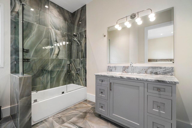 bathroom featuring marble finish floor, combined bath / shower with glass door, and vanity