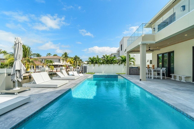 view of swimming pool featuring a patio area, a fenced in pool, fence, and a ceiling fan