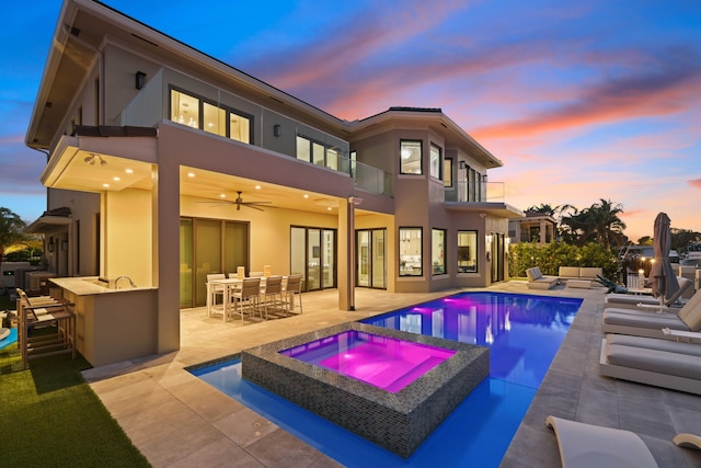 back of house featuring a patio, outdoor dry bar, stucco siding, an outdoor kitchen, and ceiling fan