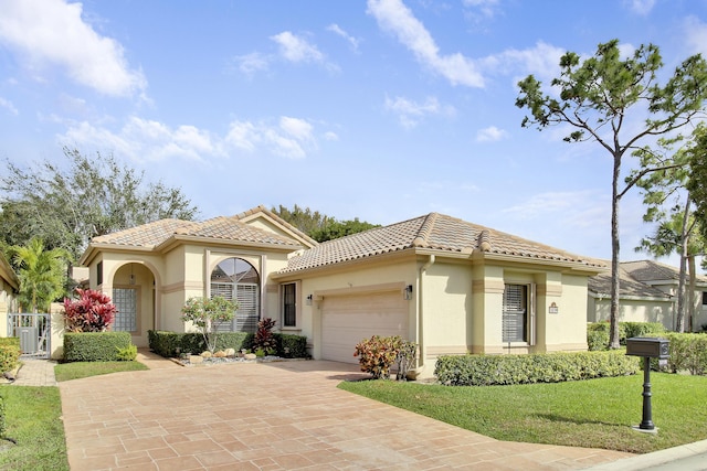 mediterranean / spanish-style house with a garage, a tile roof, decorative driveway, and stucco siding