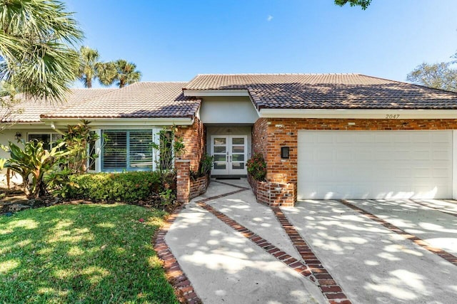 view of front of home with a garage, a front lawn, and french doors