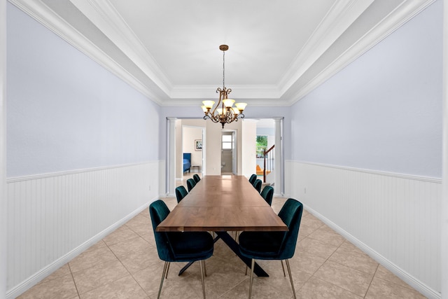 tiled dining room with crown molding, a tray ceiling, decorative columns, and a notable chandelier