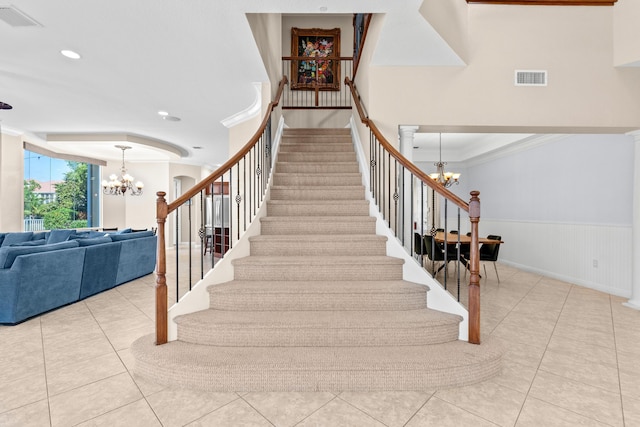 stairway featuring an inviting chandelier, tile patterned flooring, and ornamental molding