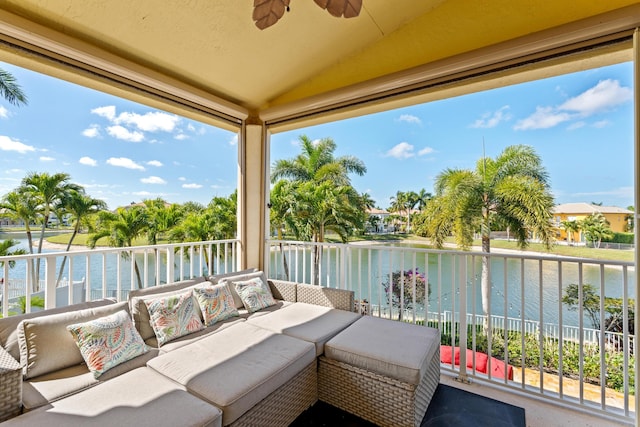 balcony with ceiling fan, a water view, and an outdoor hangout area