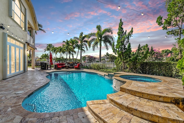 pool at dusk with a patio area, an outdoor living space, french doors, and an in ground hot tub