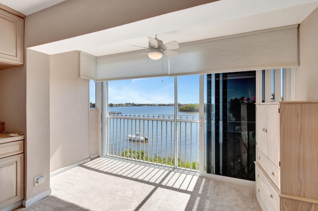 sunroom / solarium featuring a balcony, ceiling fan, and a water view