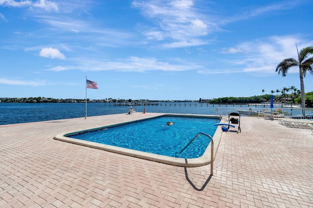 view of swimming pool featuring a water view and a patio area