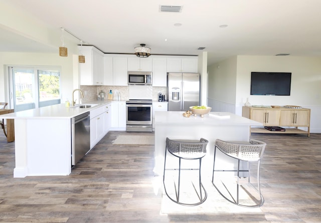 kitchen featuring sink, kitchen peninsula, white cabinets, and appliances with stainless steel finishes