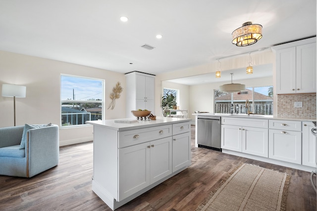 kitchen with a sink, visible vents, dishwasher, and wood finished floors