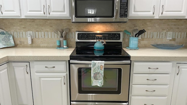 kitchen with appliances with stainless steel finishes, white cabinets, and decorative backsplash