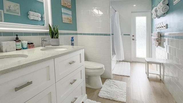 bathroom featuring tile walls, vanity, hardwood / wood-style floors, and toilet