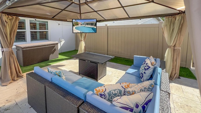 view of patio featuring a gazebo and an outdoor living space with a fire pit