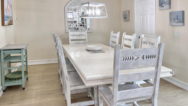 dining room with an inviting chandelier and light wood-type flooring