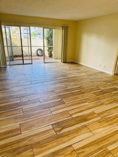 empty room featuring light wood-style floors and baseboards