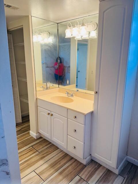 bathroom with vanity, wood finished floors, and visible vents