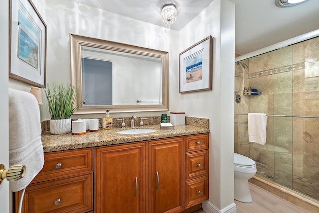 bathroom featuring toilet, vanity, and walk in shower