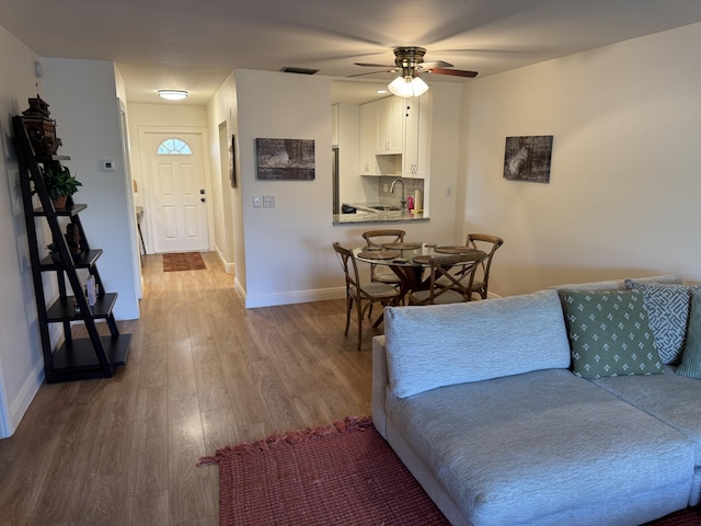 living room featuring hardwood / wood-style floors and ceiling fan