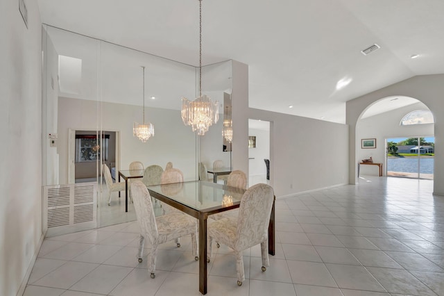 dining area featuring a notable chandelier, vaulted ceiling, and light tile patterned floors