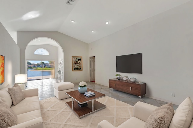 living room with high vaulted ceiling and light tile patterned flooring