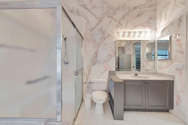 bathroom featuring toilet, a shower with door, and vanity