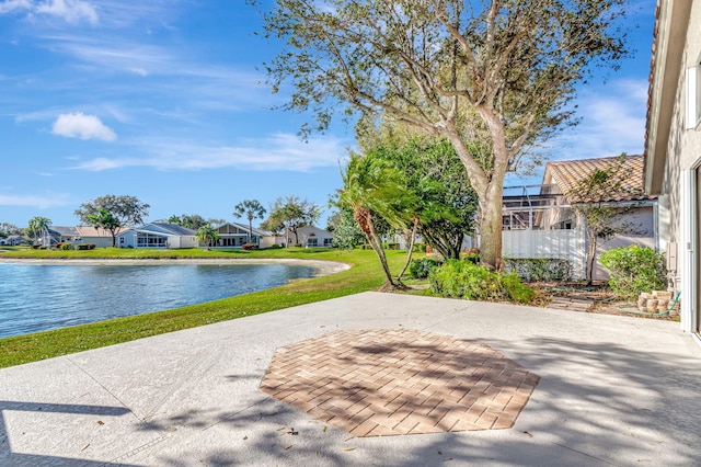 surrounding community featuring a water view, a patio area, and a lawn