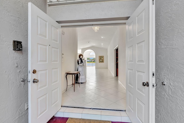 entryway featuring lofted ceiling and light tile patterned floors