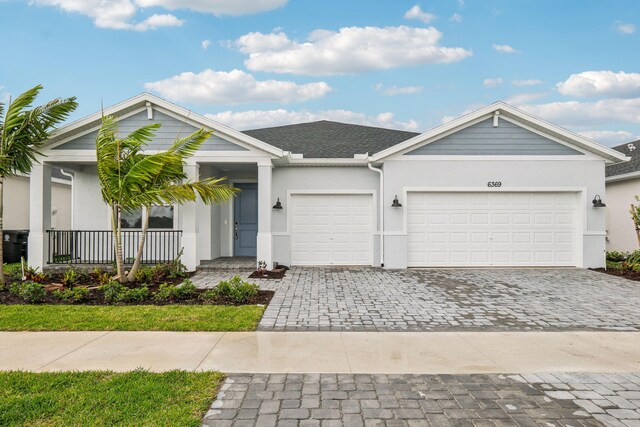 view of front of home with a garage, decorative driveway, and stucco siding