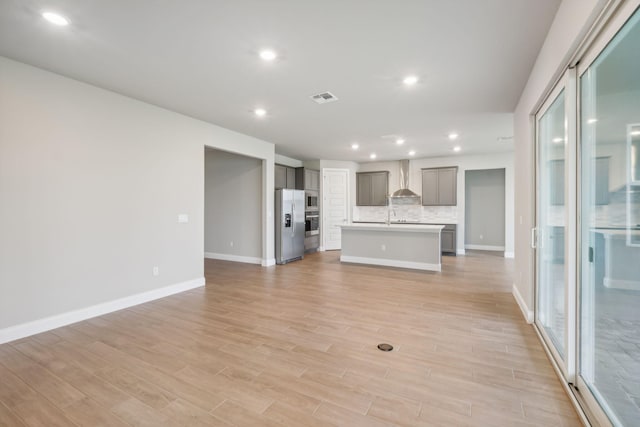 unfurnished living room featuring sink and light hardwood / wood-style flooring