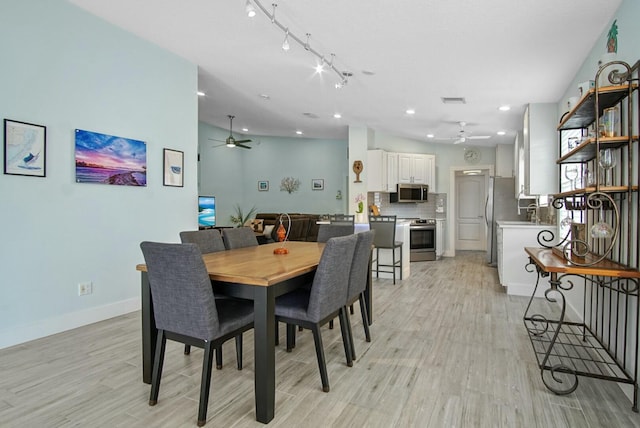 dining area featuring ceiling fan, sink, and light wood-type flooring