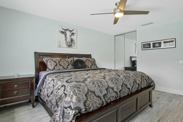 bedroom with light hardwood / wood-style flooring, a closet, and ceiling fan