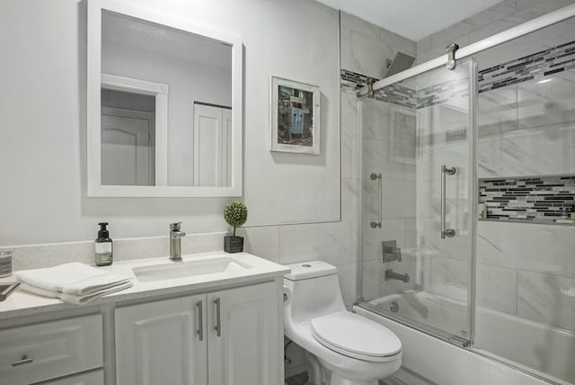 full bathroom with toilet, vanity, and bath / shower combo with glass door