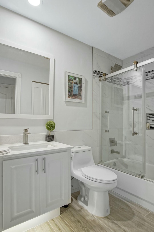 8376 SE Paurotis Ln, Hobe Sound, FL 33455 - full bathroom with vanity, toilet, visible vents, and shower / bath combination with glass door