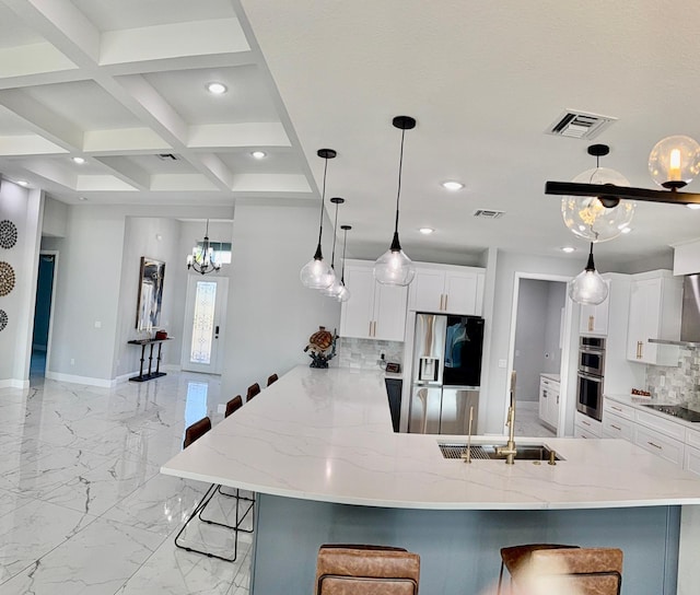 kitchen featuring appliances with stainless steel finishes, pendant lighting, a kitchen breakfast bar, and a sink