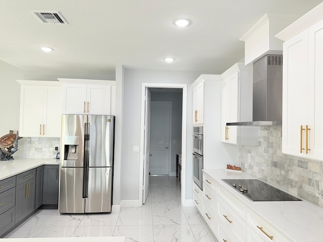 kitchen with visible vents, marble finish floor, baseboards, wall chimney exhaust hood, and stainless steel appliances