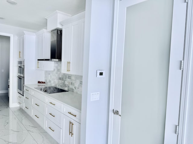 kitchen with black electric cooktop, white cabinetry, marble finish floor, backsplash, and wall chimney exhaust hood