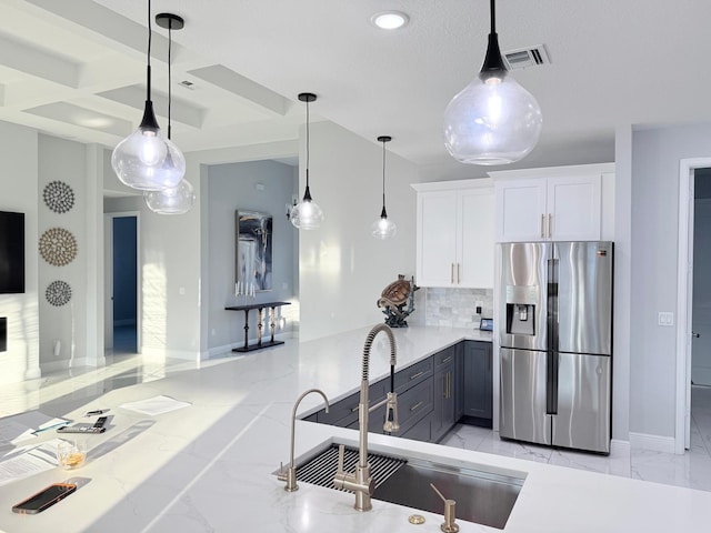 kitchen featuring marble finish floor, baseboards, white cabinetry, stainless steel fridge with ice dispenser, and a sink