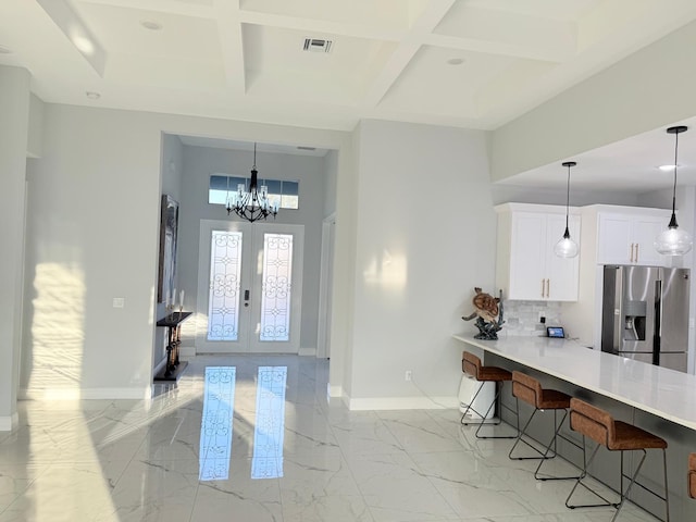 interior space featuring stainless steel fridge, baseboards, a kitchen breakfast bar, and visible vents