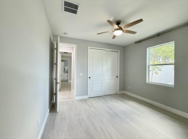 unfurnished bedroom featuring visible vents, baseboards, a closet, and light wood-type flooring