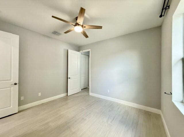 unfurnished bedroom featuring baseboards, ceiling fan, light wood finished floors, and visible vents