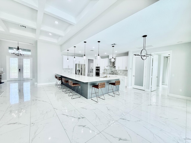 kitchen featuring stainless steel appliances, a breakfast bar, light countertops, decorative light fixtures, and an inviting chandelier