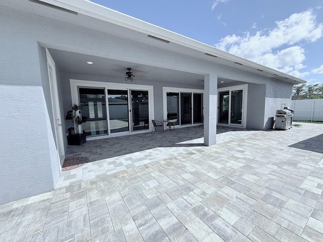 view of patio with ceiling fan, area for grilling, and fence