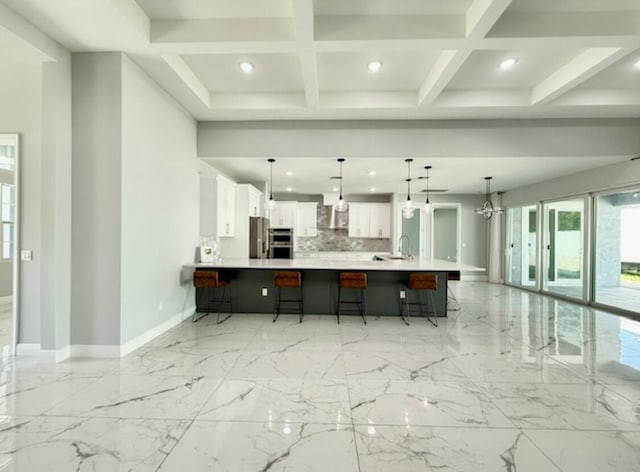 kitchen with light countertops, recessed lighting, baseboards, stainless steel appliances, and a kitchen bar