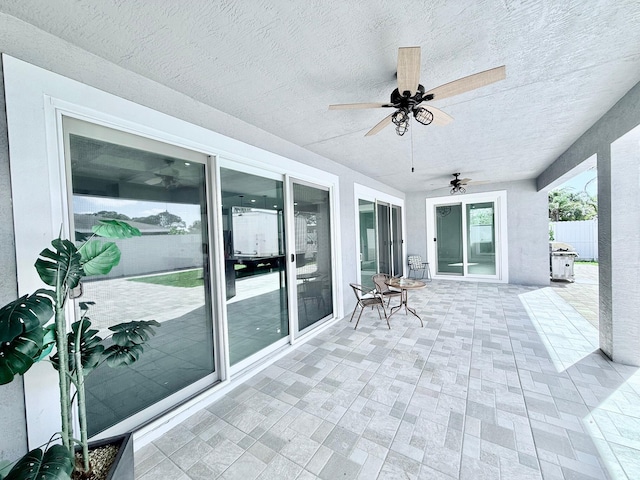 view of patio / terrace with fence and a ceiling fan