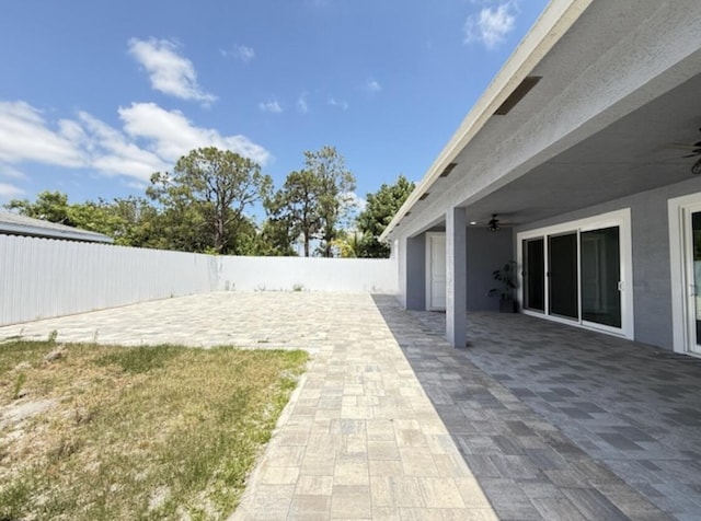 view of yard featuring a fenced backyard, a patio, and ceiling fan