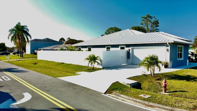 view of front of house featuring driveway, metal roof, a standing seam roof, a front yard, and stucco siding