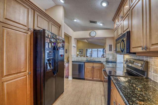 kitchen featuring sink, vaulted ceiling, light wood-type flooring, decorative backsplash, and black appliances