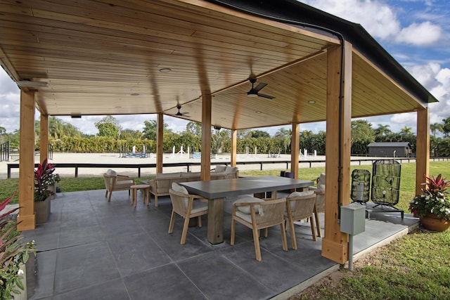 view of patio with outdoor dining area, ceiling fan, and a gazebo