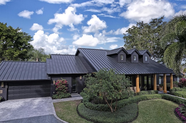 view of front of home featuring decorative driveway, a standing seam roof, metal roof, and an attached garage